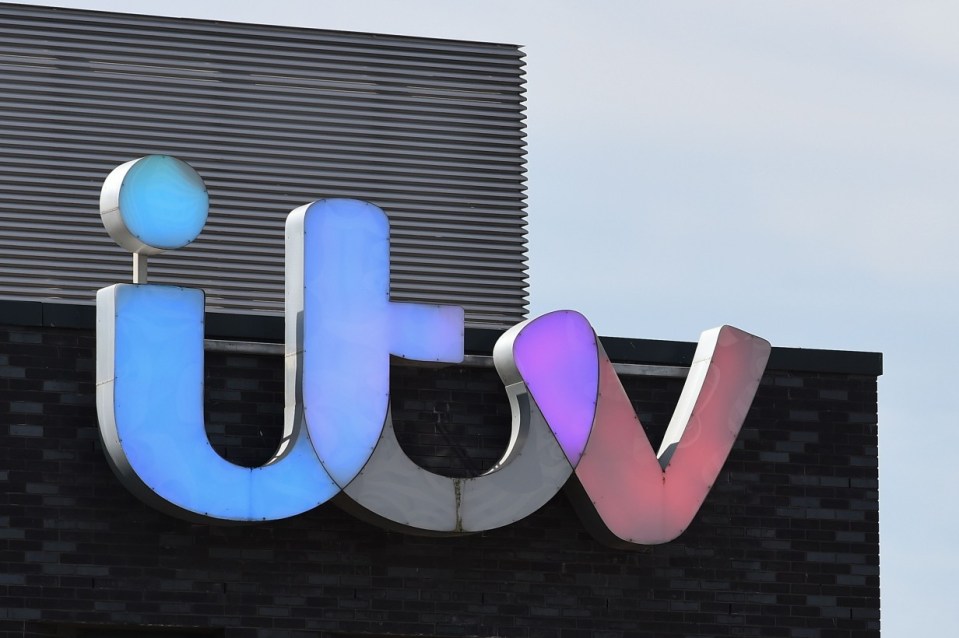 a sign for itv is lit up in blue and red