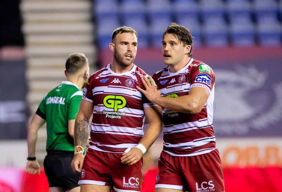 two rugby players wearing jerseys that say greenmount projects and lcs