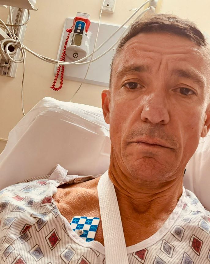 a man in a hospital bed with a pager that says ' emergency ' on it