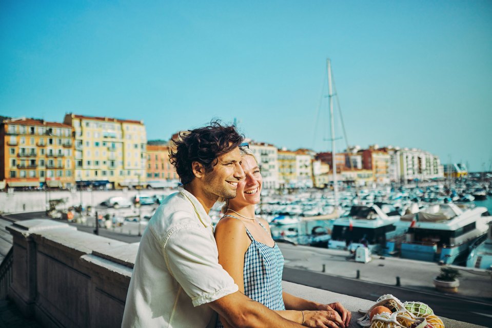 a man and woman are hugging in front of a marina