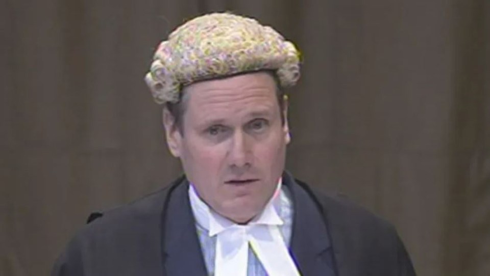 a man in a suit and wig is giving a speech .