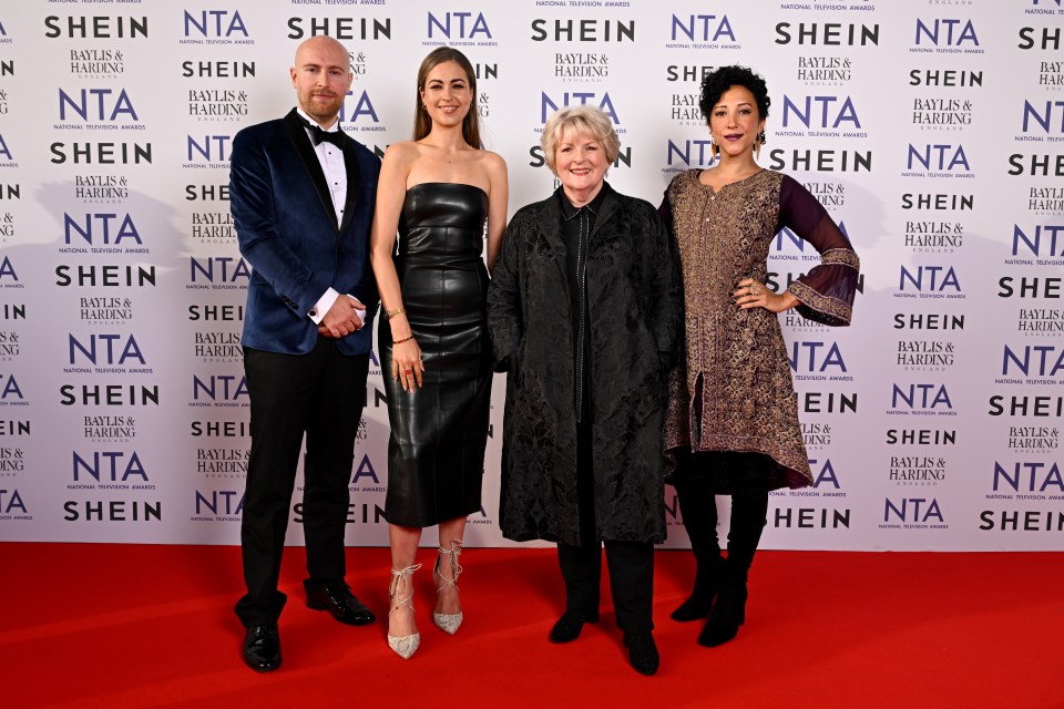 a group of people standing in front of a wall that says shein