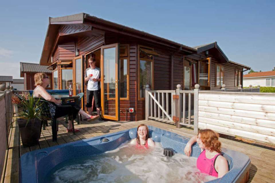 a woman in a pink bathing suit sits in a hot tub