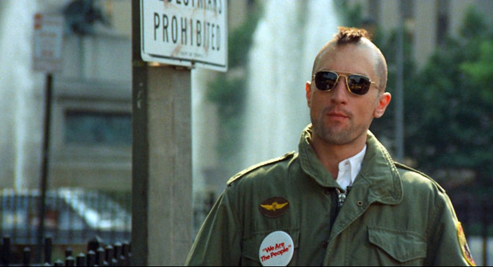 a man wearing sunglasses stands in front of a sign that says prohibited