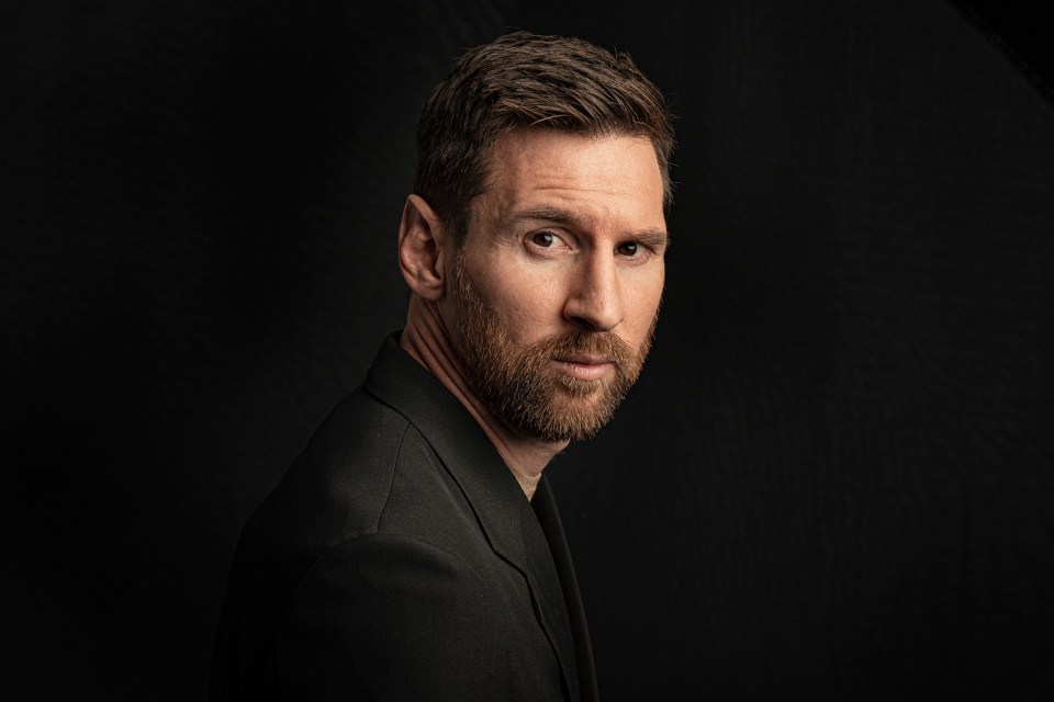 a man with a beard is wearing a black suit