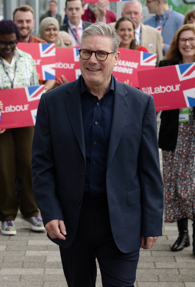 a man in a suit holds a sign that says labour