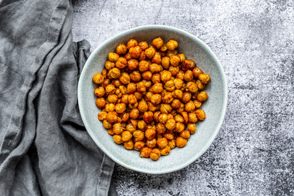 a bowl of chickpeas sits on a gray cloth