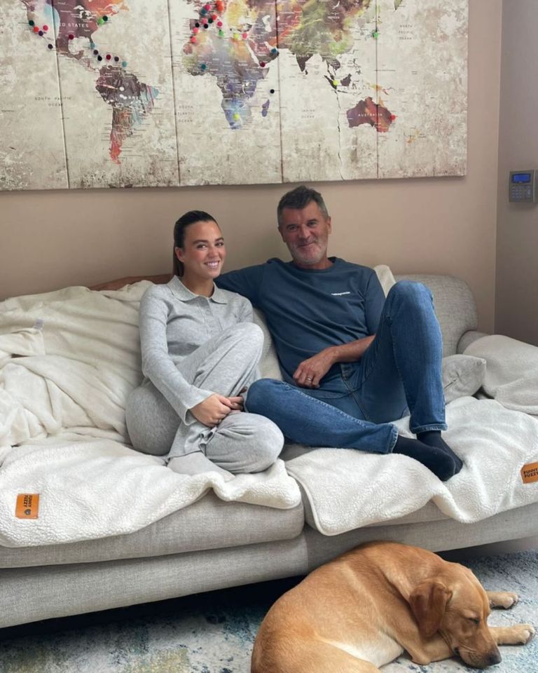 a man and a woman sit on a couch with a dog