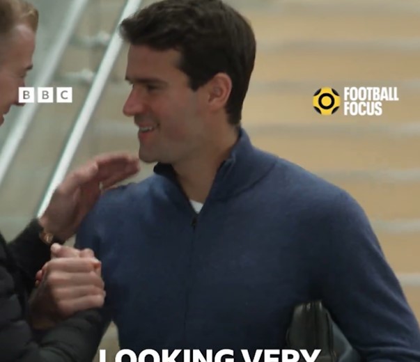 two men shaking hands in front of a sign that says football focus