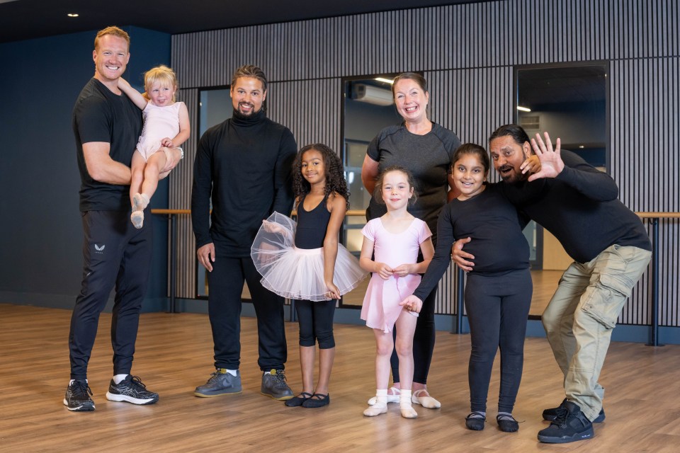 a group of people posing for a picture in a dance studio
