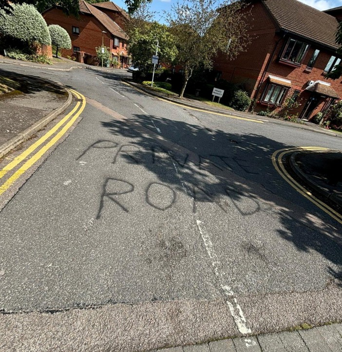 Graffiti stating private road at the entrance to the cul-de-sac. Photo released September 5 2024. A disgruntled resident has taken to blocking a footpath with their car in a long-running row over primary school parking.A cul-de-sac in Bushey, Hertfordshire, has been in an ongoing feud with parents who use the private road to park when dropping their kids off at school. The Meadowcroft estate just off the high street is connected by a footpath to St Hildas Preparatory School, which makes it an ideal spot for parents to park- to the frustration of residents.Around 18 months ago, ANPR cameras were installed to discourage parents parking and £100 penalty charges started appearing in the post..