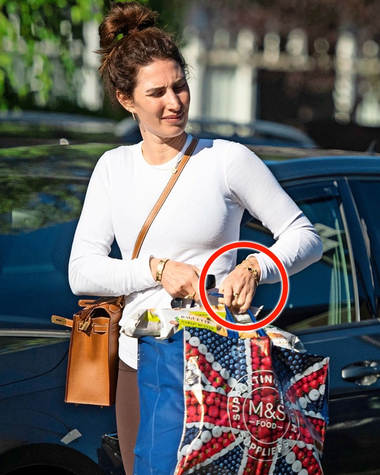 a woman holding a bag that says m & s on it