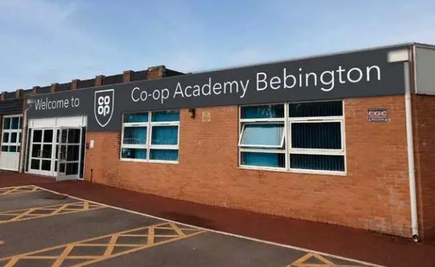 a large brick building with a sign that says welcome to co-op academy bebington .