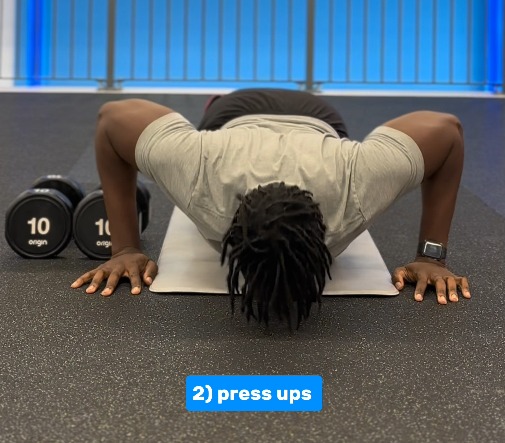 a man is doing push ups on a mat with a blue button that says 2 press ups
