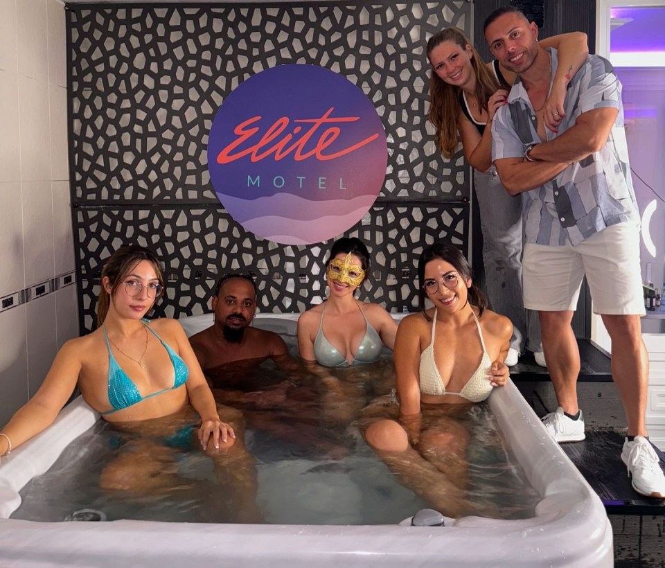 a group of people in a hot tub at the elite motel