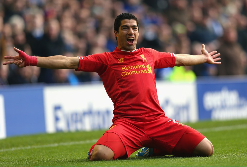 soccer player wearing a red shirt that says standard chartered