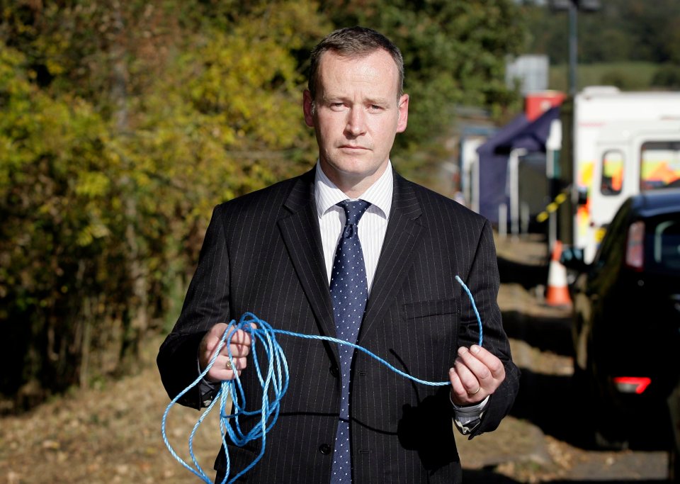 a man in a suit and tie is holding a blue rope