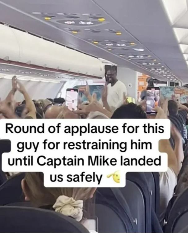 a crowd of people on an airplane applauding a man for restraining him until captain mike landed us safely
