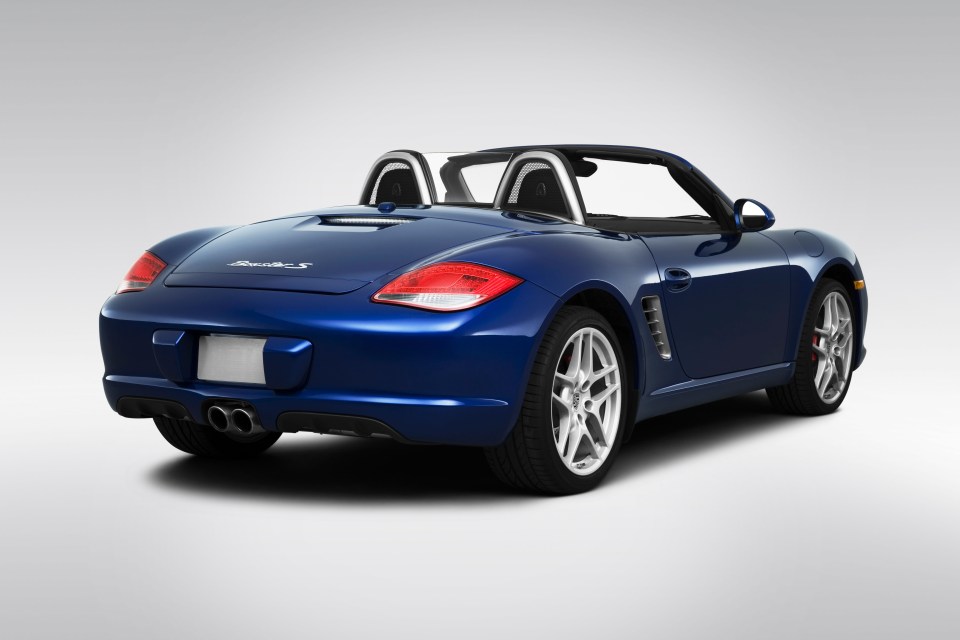 a blue porsche boxster s with the top down