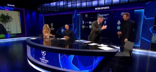 a group of people are sitting around a table in a cbs sports studio .
