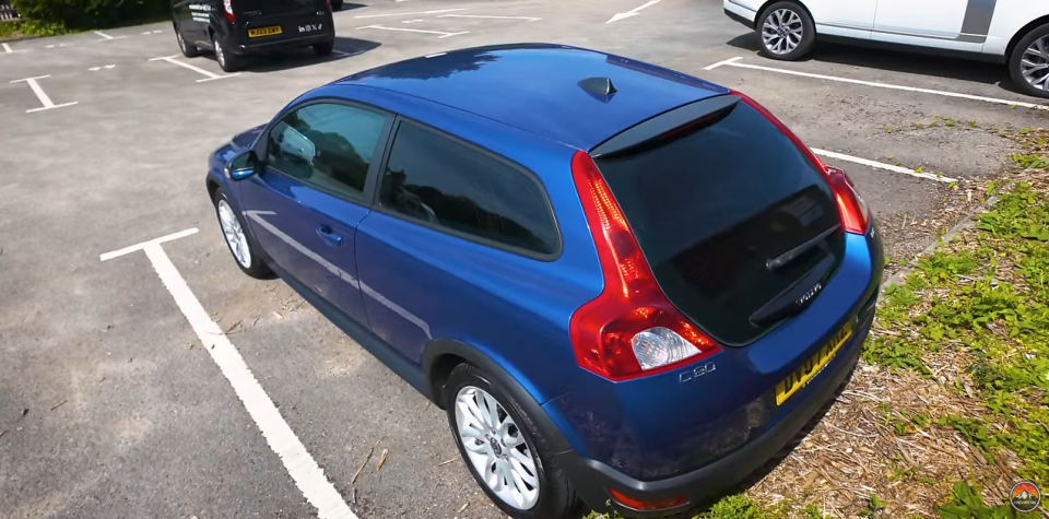 a blue volvo car is parked in a parking lot