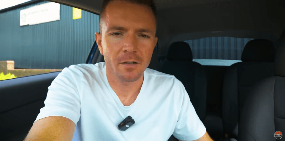 a man in a white shirt is sitting in the back seat of a car