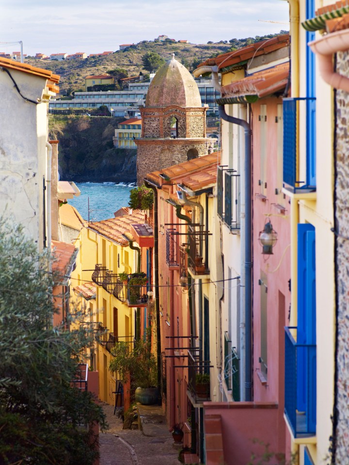 a narrow street with a tower in the background