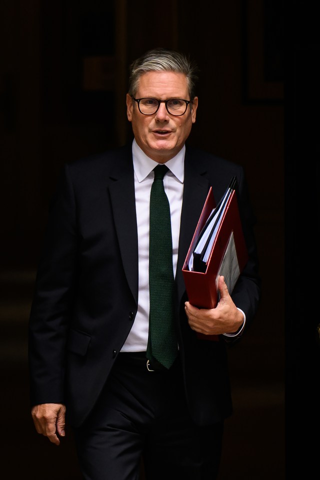 a man in a suit and tie is holding a red folder