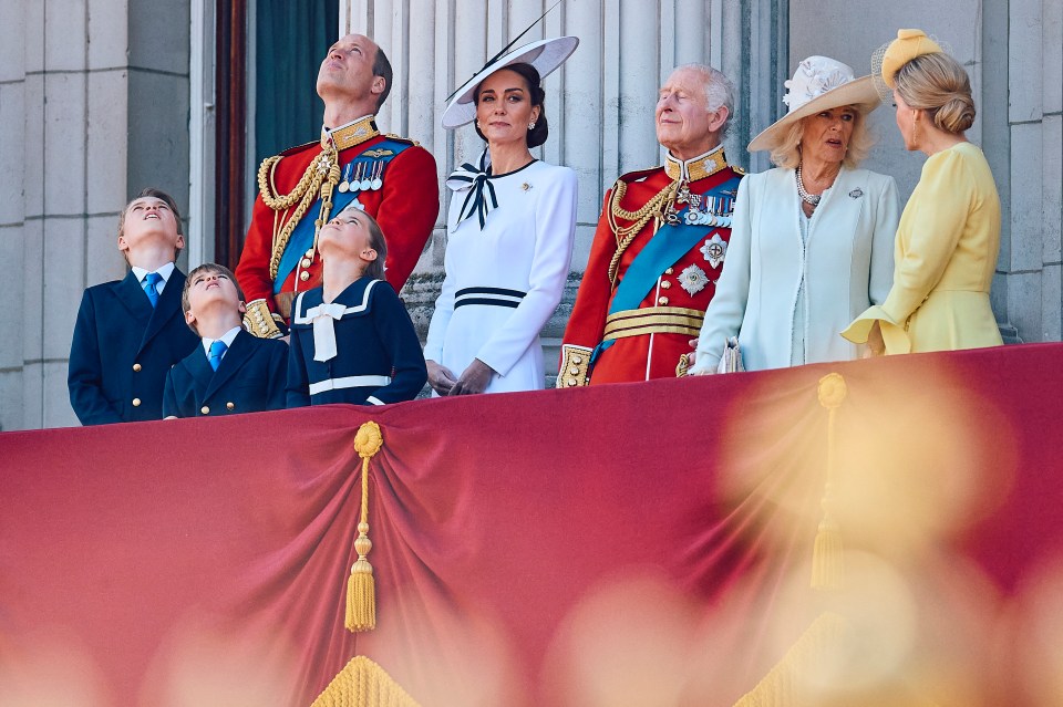 a group of people standing on a balcony looking up at the sky