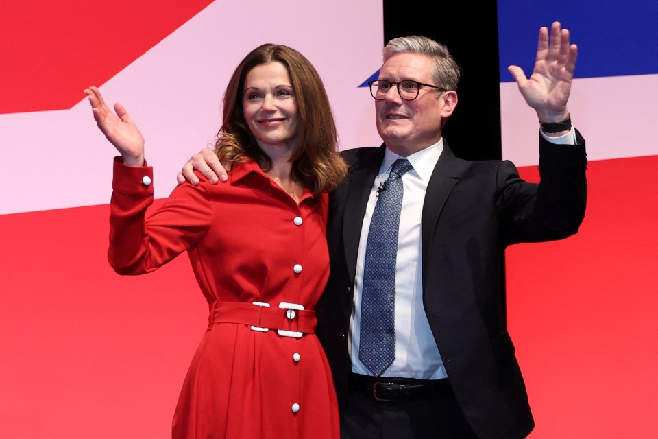 a man in a suit and tie stands next to a woman in a red dress