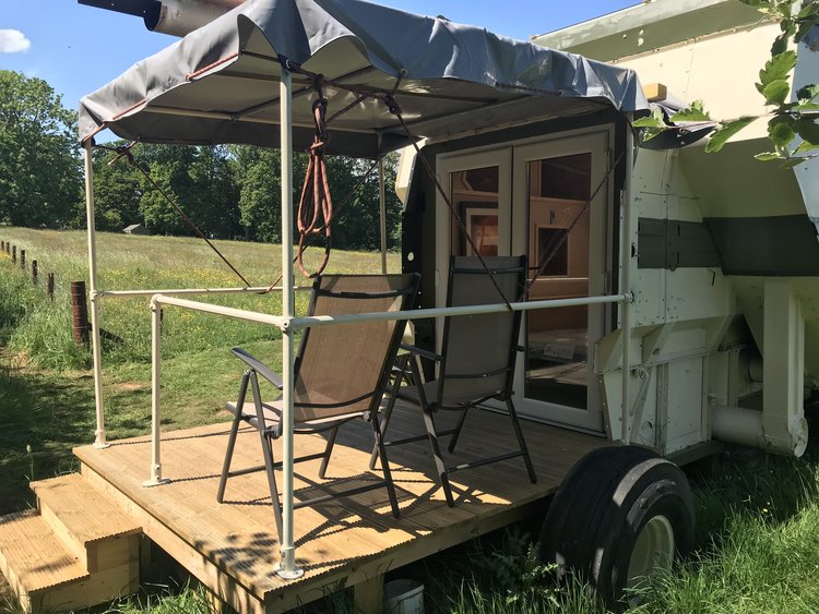 a trailer with a canopy and chairs in front of it