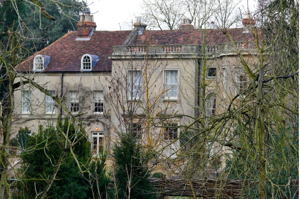 a large house is surrounded by trees and a sign that says ' george and ariel ' on it