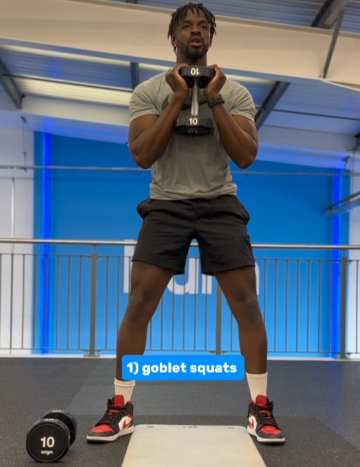 a man is doing goblet squats in a gym