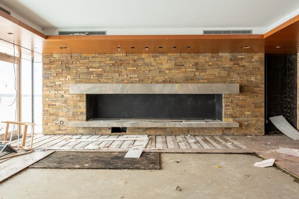 an empty room with a brick wall and a fireplace