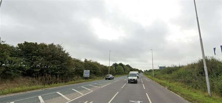 a white van is driving down a country road .