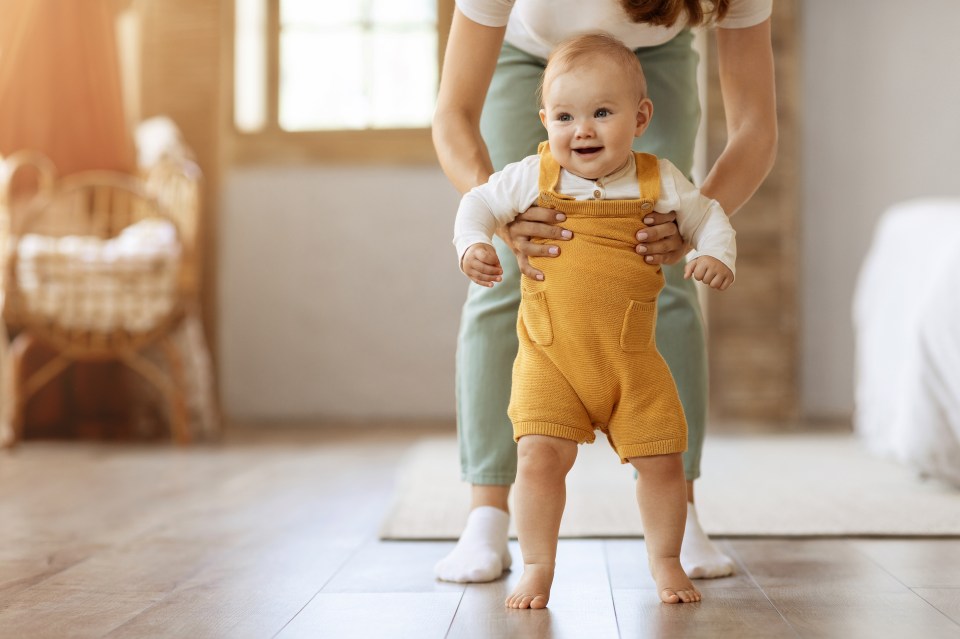 a baby in yellow overalls is being held by a woman
