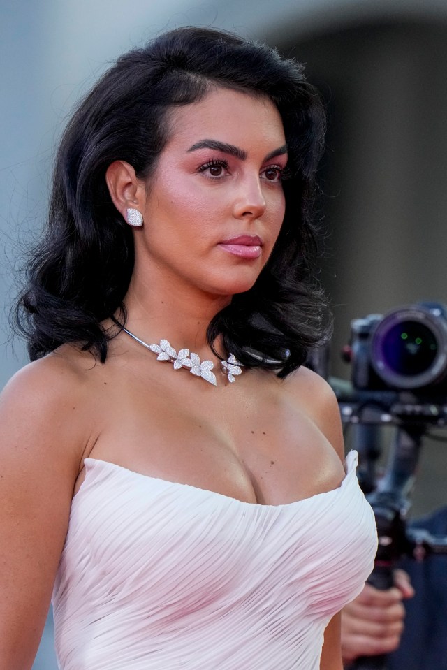 a woman in a white strapless dress is standing in front of a camera