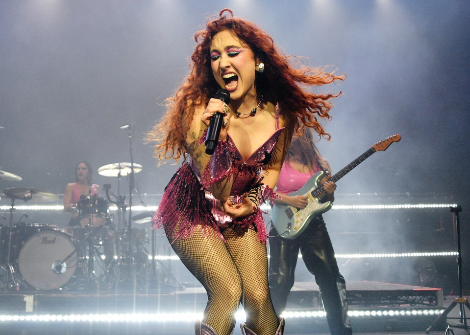 a woman singing into a microphone with a pearl drum in the background