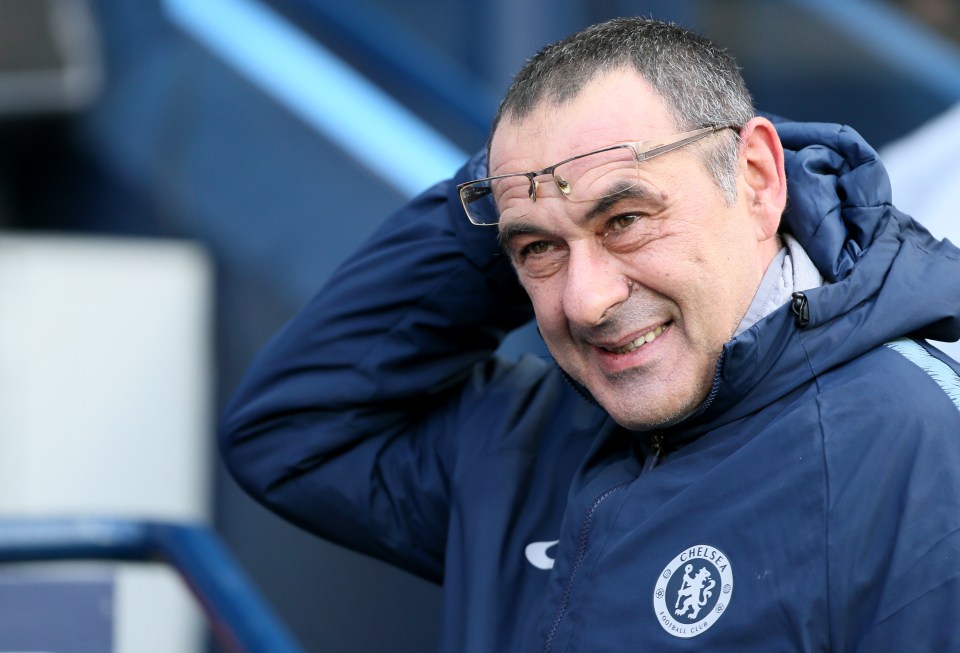 a man wearing glasses and a jacket that says chelsea on it