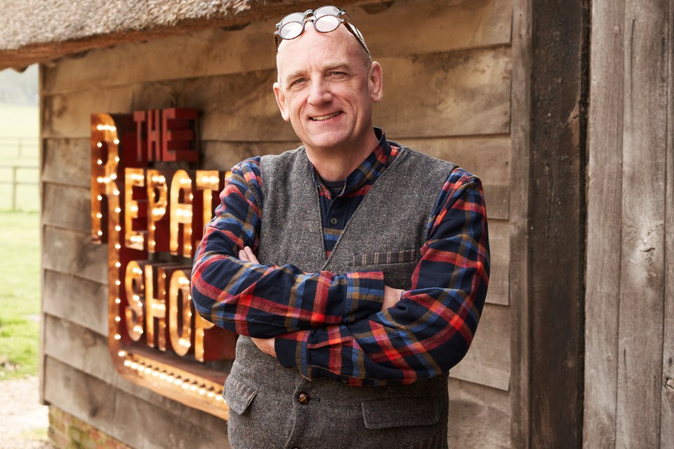 a man stands in front of a sign that says the repair shop