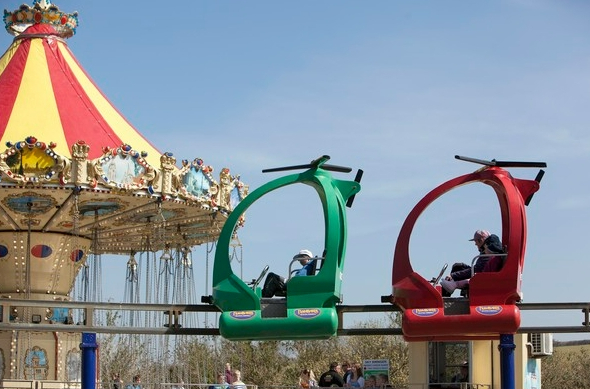 a carousel and a helicopter ride at an amusement park