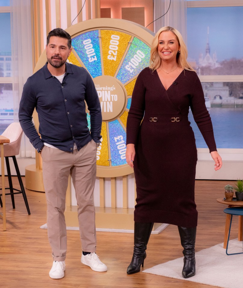 a man and a woman stand in front of a wheel that says morning 's spin to win