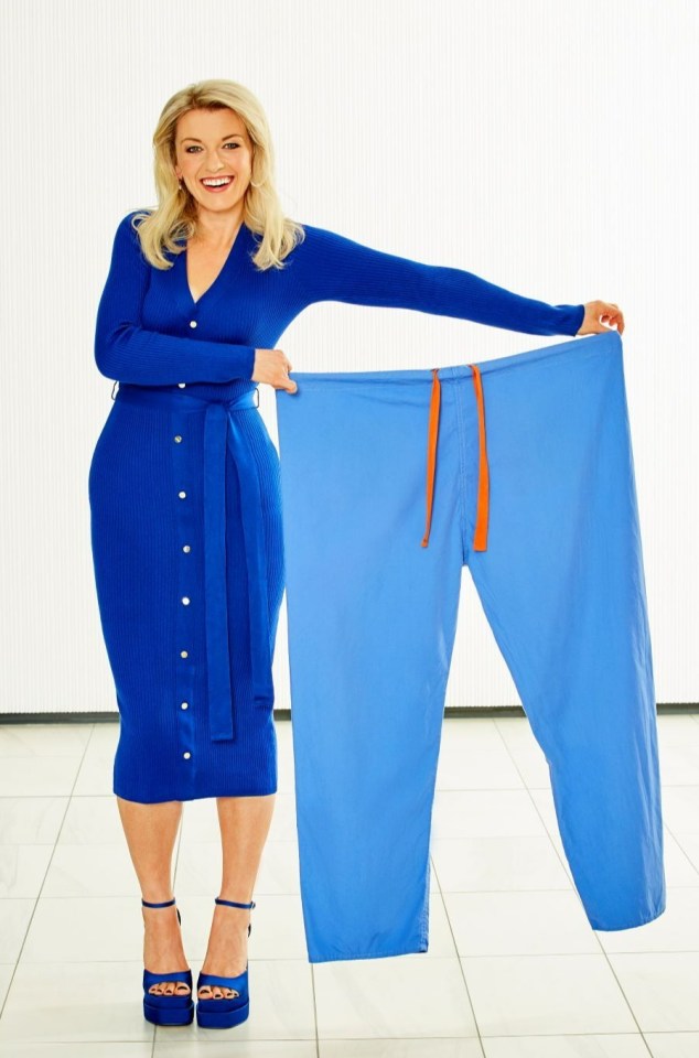 a woman in a blue dress is holding a pair of blue pants