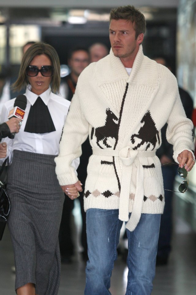 a man wearing a sweater with horses on it holds hands with a woman