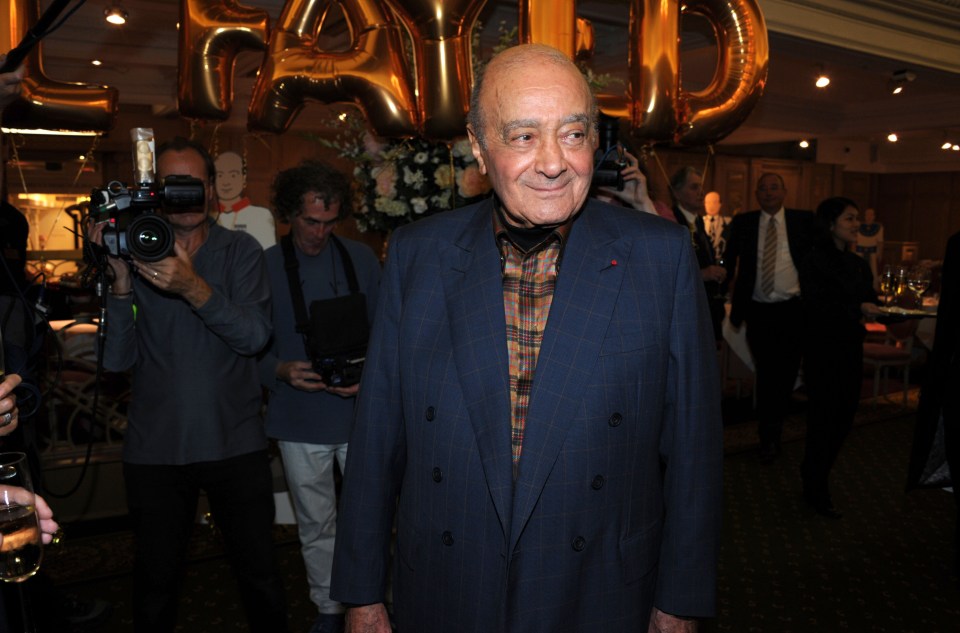 a man in a suit stands in front of balloons that say harrods