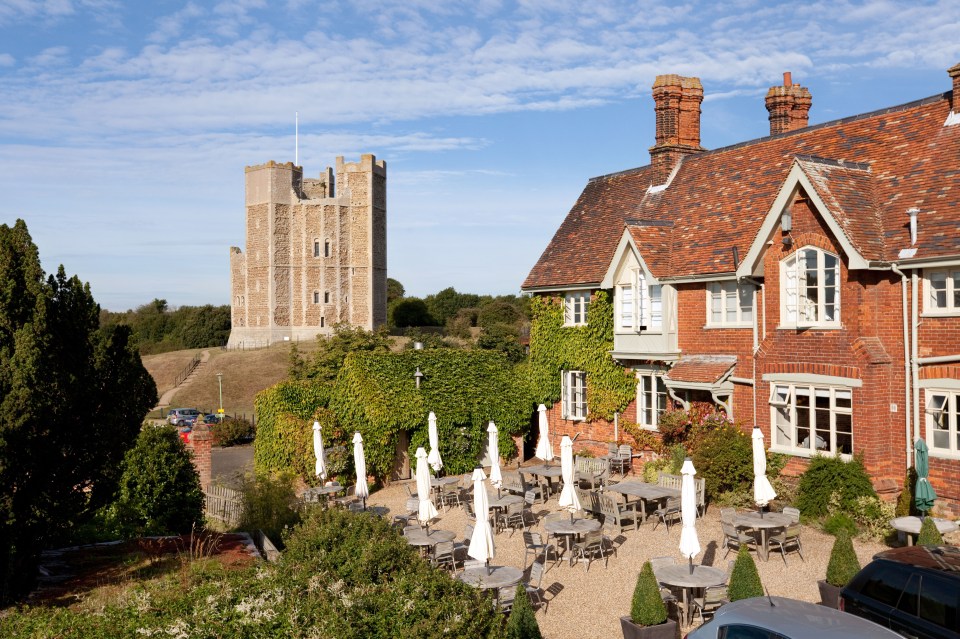 a large brick building with a castle in the background