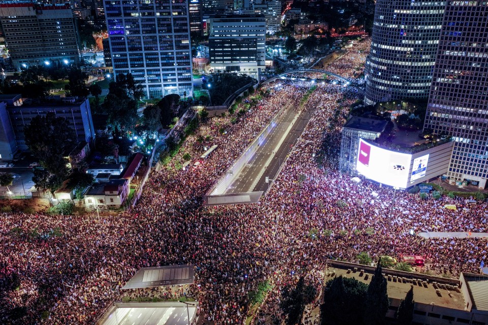 a large crowd of people are gathered in a city at night