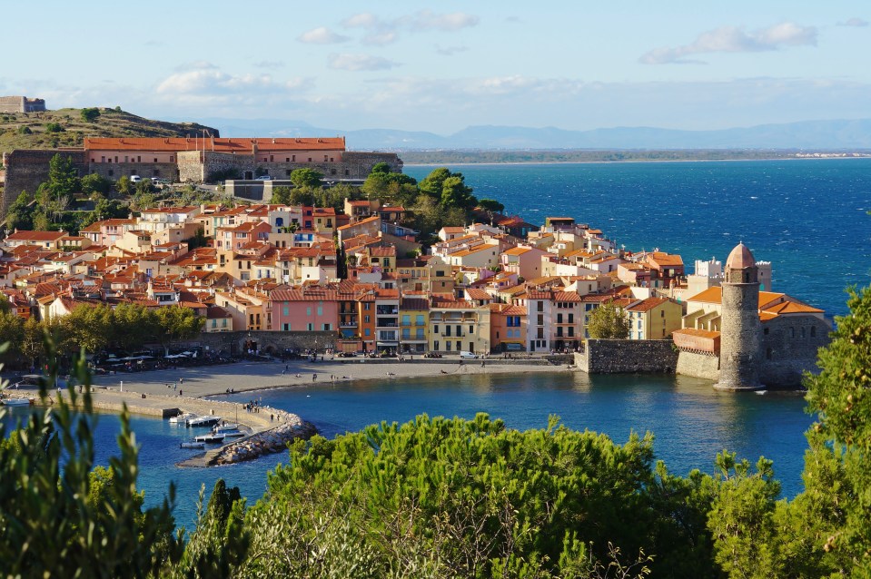 a small town sits on a hill overlooking the ocean