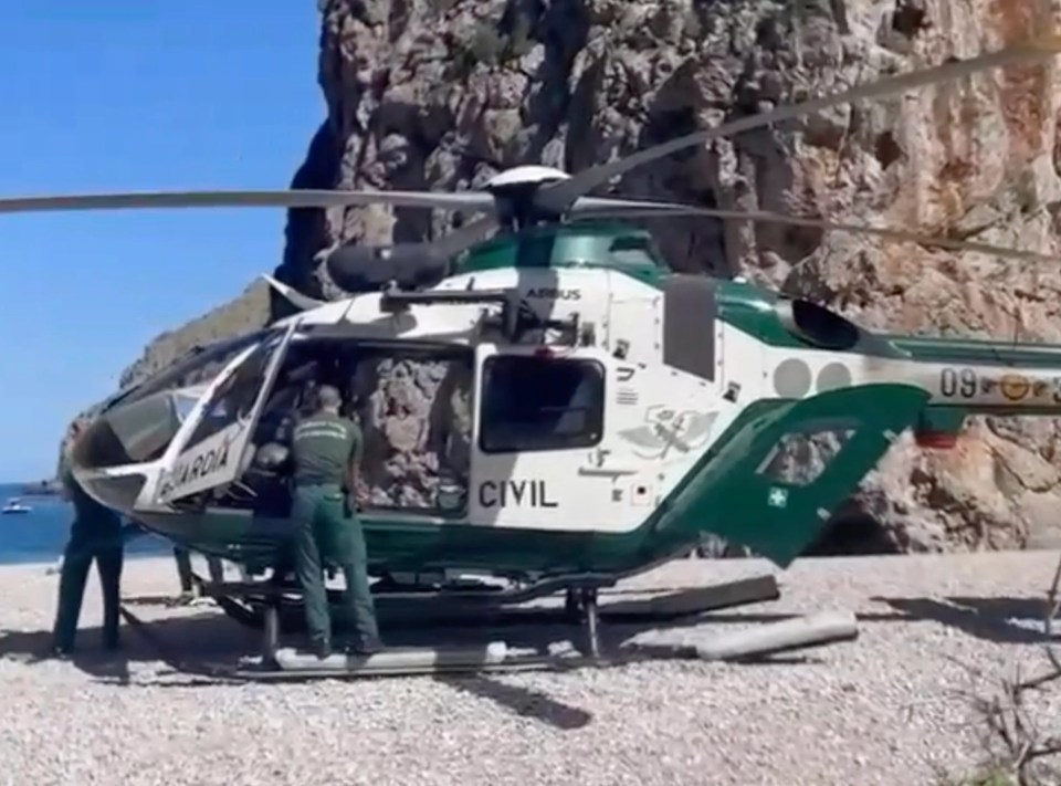 a helicopter from the guardia civil is parked on the beach