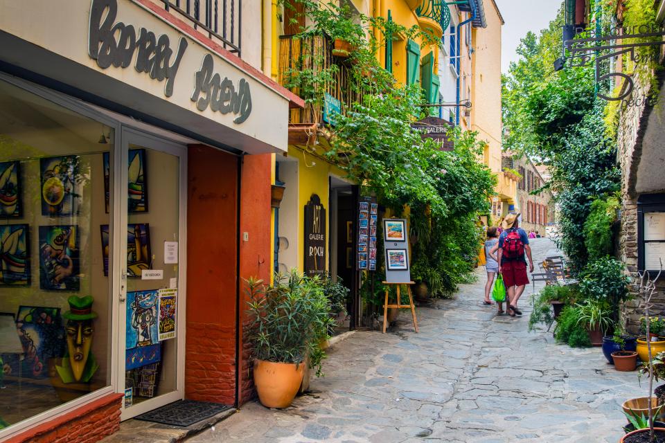 a couple walking down a narrow alleyway in front of a store called bonifacio